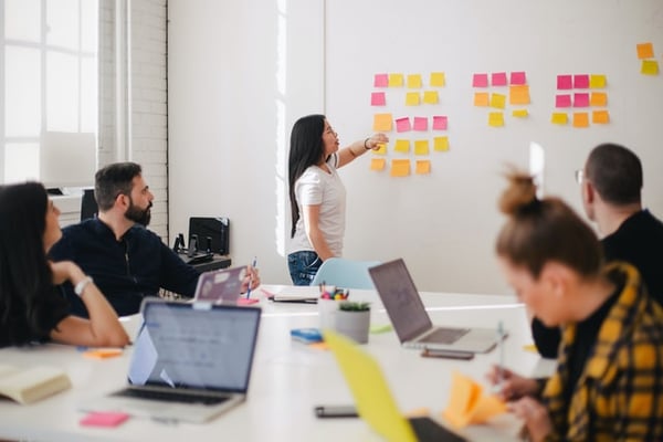 Populus Group's Return to Work Guide During COVID-19, featuring stock image of a group meeting.