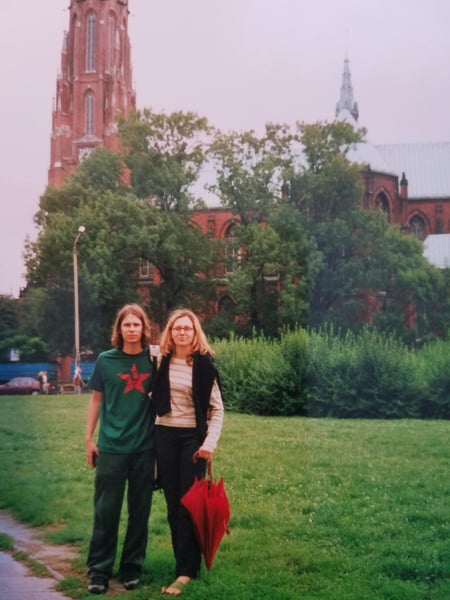 Tom and his wife posing in front of a cathedral.