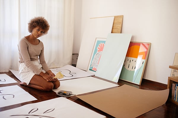 A Black artist sitting on the floor, via Pexels.com.