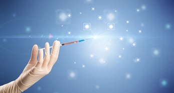 Female doctor hand holding syringe with shiny crosses in the background