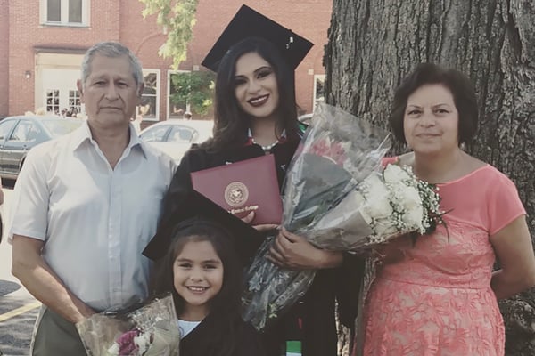 Claudia Gomez on her graduation day with her father (left), daughter (middle), and mother (right).