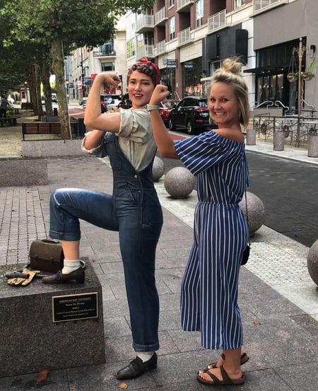 Brooke at the National Harbor in Maryland posing with a picture of Rosie the Riveter, the classic depiction of women in the 1940s who went to work in factories during WWII. Rosie is a great role model because she represents women's independence in the workplace!