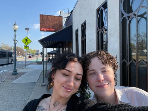 Remy and her girlfriend taking a selfie on the sidewalk.