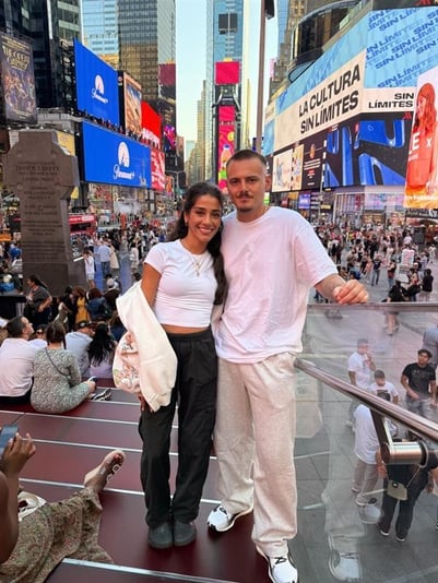 Reem and her husband post on steps in a city.
