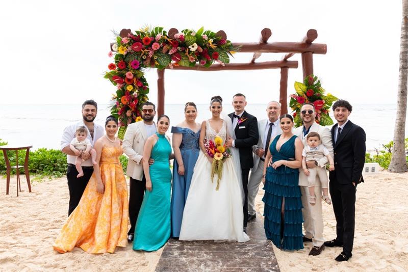 Reem, her husband, and their family gathered under an awning on the beach on their wedding day.