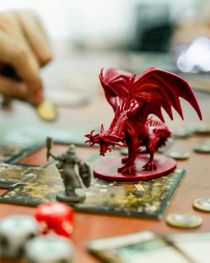 A Dungeons and Dragons board came shows a red dragon figure facing off against a player's smaller figuring.