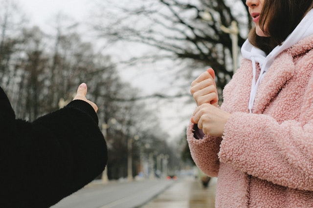 two people signing on a street in the winter